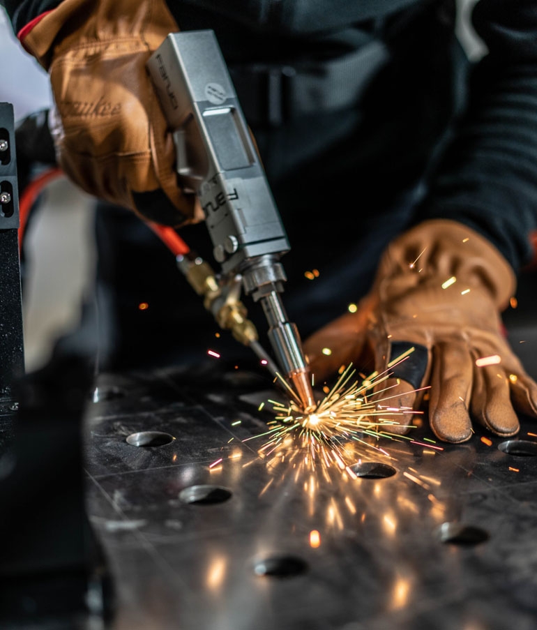 Spawacz pracujący spawarką laserową